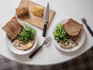Omelette eggs with mushrooms and arugula. Breakfast with cheese and bread