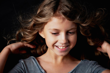 kinky girl with long hair. In the Studio on a black background. A fairy tale for children. Lives in the frame