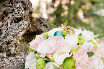 wedding gold rings lie on a wedding bouquet