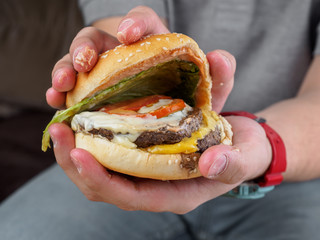 Meet burger in hands of man. Close up