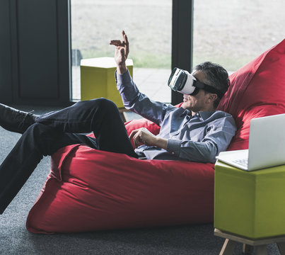 Man sitting in beanbag wearing VR glasses
