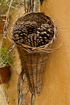 Pine cones in the wicker hanging on the wall in Pienza