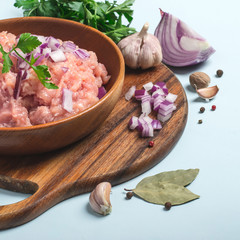 Raw chicken meat mince in a bowl with spices