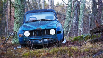 Obraz na płótnie Canvas Abandoned car in forest