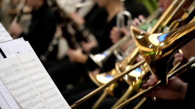 Footage of an orchestra playing on their instruments...
