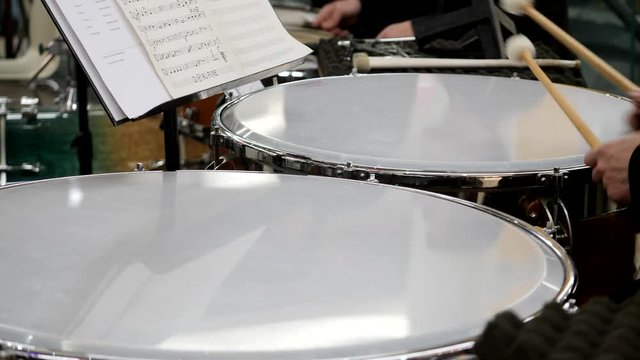 Close up footage of a musician playing on the kettledrum...