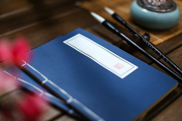 chinese vintage old book,incense burner and brush on wooden table