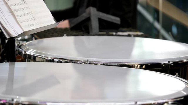 Close up footage of a person playing on the kettledrum
