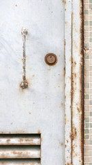 The grunge metal door close-up with handle and key lock