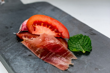 Pizarra, hierbabuena, jamón tomate y ajo