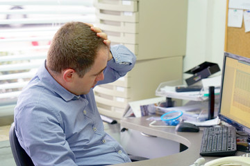 A man in stress in front of a computer. Poor economy concept. Face expression, emotion