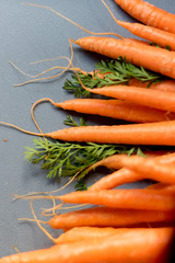 Carrots on chopping board with green stems