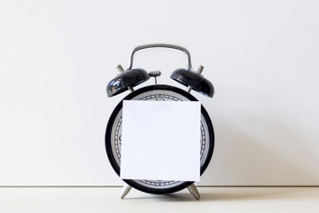 Alarm clock and spectacle on brown desk with white background. Education and business concept.