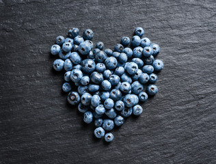 Heart made of blueberry on black slate. Top view. High resolution product.