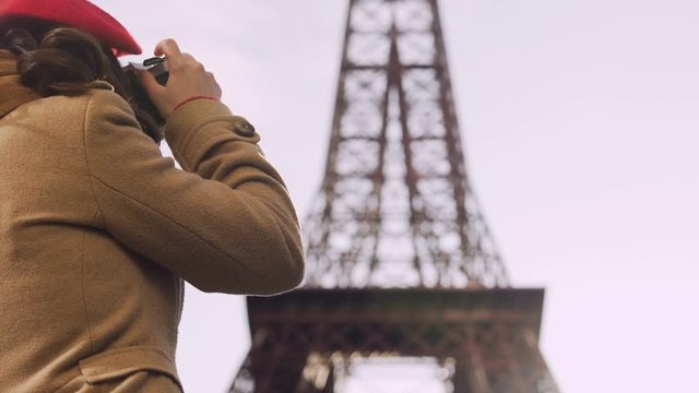 Curious female tourist photographing Eiffel Tower, tourism, vacation in Paris