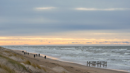 People walking on beach in winter evening in Palanga 