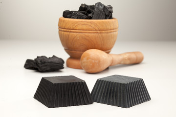 two hand maded black soap from activated carbon on white background