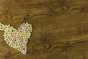 Close-up marshmallow sweets placed in heart shape.valentine's day and love concept on wooden background
