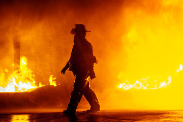 Fire chief walking in front of fire during firefighting exercise