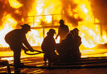 Firefighter adjusting firehose during firefighting exercise