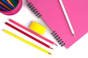 colored pencils in the basket, Eraser and notebook on white background