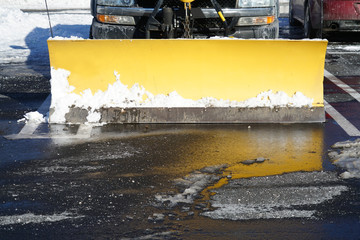 Snowplow in the parking lots with snow removed