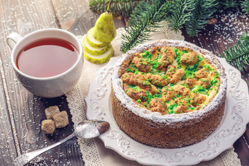 Homemade Christmas or New Year holiday pear pie decorated in a rustic style. Concept of festive desserts