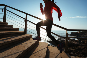 sporty fitness female runner running upstairs at coast trail