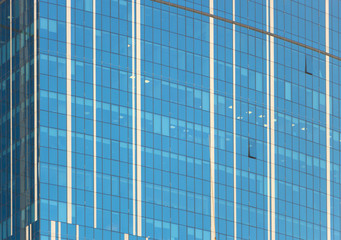 Fototapeta na wymiar Clouds Reflected in Windows of Modern Office Building