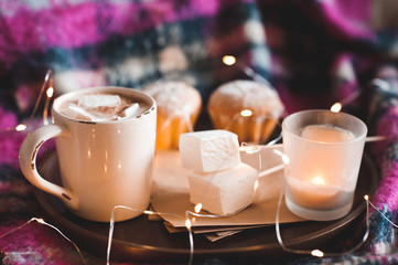 Obraz na płótnie Canvas Mug of sweet marshmallow with cakes and candle at backgrouns. Winter season. Good morning.
