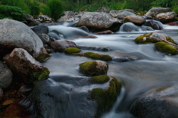 Fototapeta na wymiar Small rivers with stones in long exposure