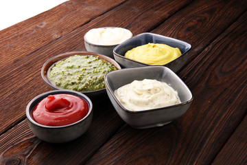 Set of sauces - ketchup, mayonnaise, mustard bbq sauce, pesto, mustard on wooden table