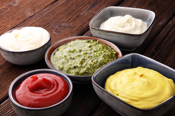 Set of sauces - ketchup, mayonnaise, mustard bbq sauce, pesto, mustard on wooden table