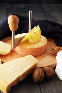 Special cheese knives. The girolle scraper in cheese wheel. Cheese shaving decoration.