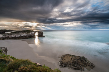 storm on the beach of the Cathedrals, with threatening clouds on the horizon unloading rain