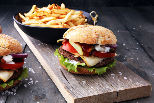 fresh tasty burger and french fries on wooden table
