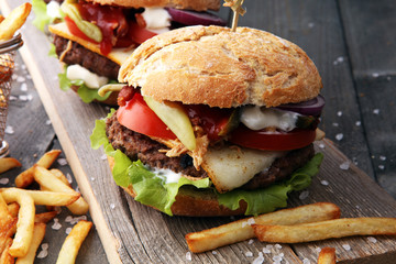fresh tasty burger and french fries on wooden table