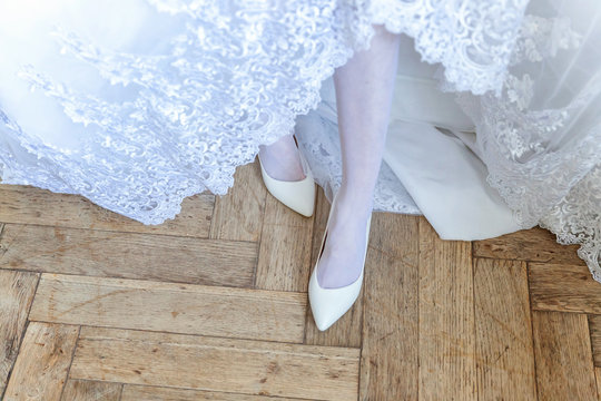the bride wears white shoes on foot in the wedding day. close-up shoot - Powered by Adobe