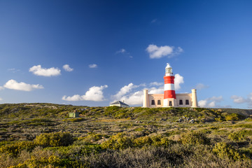 Fototapeta na wymiar Beautiful view of Cape Agulhas Lighthouse. The lighthouse is located at the southernmost point of Africa and at the same time lies at 20 degrees east latitude exactly. Popular tourist destination.