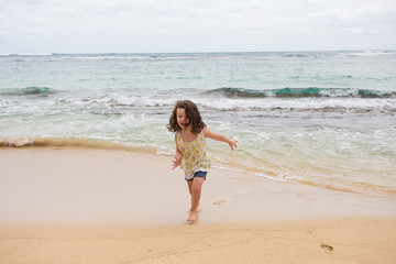 Fototapeta na wymiar Child Playing on Beach in Oahu Hawaii