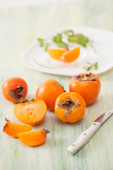 Fresh ripe persimmons in a dish on the kitchen table