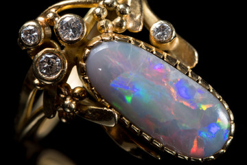 A golden ring with a colorful opal gemstone