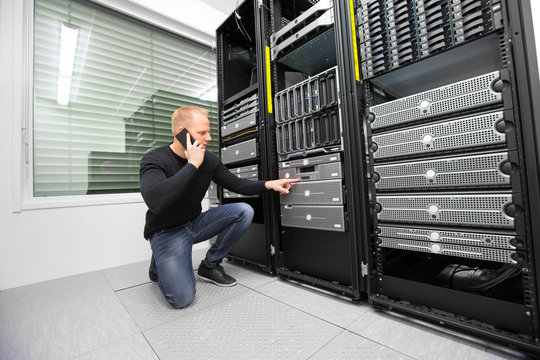 Consultant Using Smartphone While Monitoring Servers In Datacent