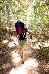 Father hiking with child in backpack carrier