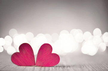 Hearts on a wooden table and background is a bokeh.