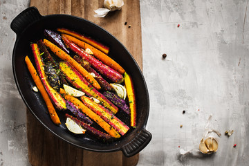 Colorful carrots and potatoes in a black pan