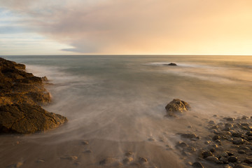 The calm sea in a very cloudy sunset