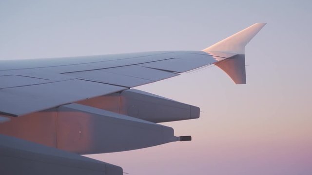plane wing during flight in sunrise