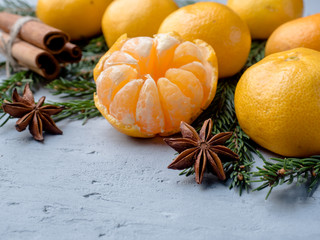 Fresh tangerines with branches of Christmas tree, star anise cinnamon on gray concrete background Copy space