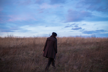 Man walking in the field during sunset 